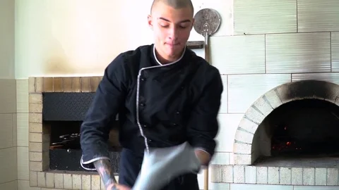 A young pizza maker prepares pizza in the kitchen of the restaurant. The cook Stock Footage 84831407