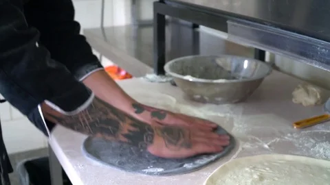 A young pizza maker prepares pizza in the kitchen of the restaurant. Mix the Stock Footage 84831505