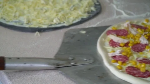 A young pizza maker prepares pizza in the kitchen of the restaurant. The cook Stock Footage 84831797