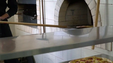 A young pizza maker prepares pizza in the kitchen of the restaurant. The cook Stock Footage 84831881