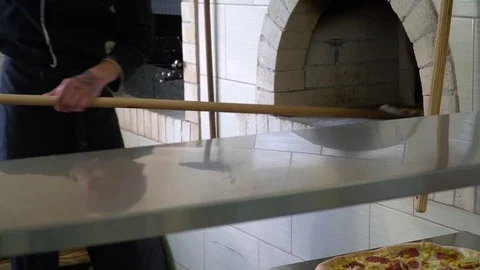 A young pizza maker prepares pizza in the kitchen of the restaurant. The cook Stock Footage 84831910