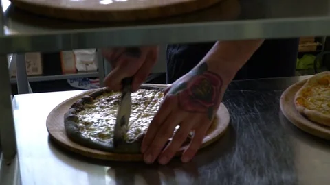 A young pizza maker prepares pizza in the kitchen of the restaurant. The cook Stock Footage 84831947