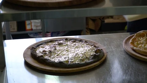 A young pizza maker prepares pizza in the kitchen of the restaurant. The cook Stock Footage 84831970