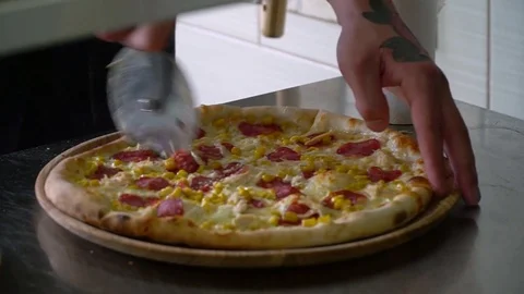 A young pizza maker prepares pizza in the kitchen of the restaurant. The cook Stock Footage 84832031