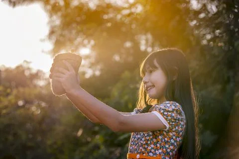 Young plant and girl. Little cute Girl give small plant to Sunshine. Stock Photos
