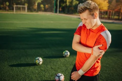Young player have problem in forearm. He hold hand on that and suffer from pain Foto stock