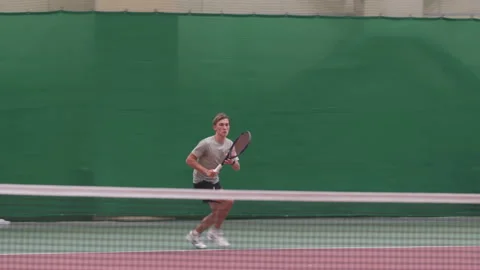 Young player moves fast across court returning sharp serve Vídeos de archivo 317151156