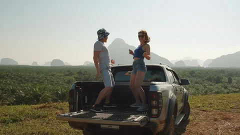 Young playful couple dancing in the back of a pickup truck Stock Footage 128345200