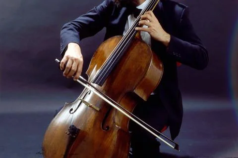 Young playing the cello violonchelo  on isolated black background Stock Photos