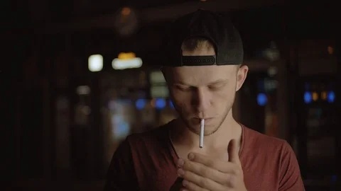 Young pleasant-looking Slavic man lighting cigarette, smoking. Nice blue-eyed Stock Footage 91155306