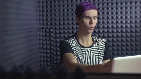 Young pleased streamer with purple bangs taking video review about something in Stock Footage 70792630
