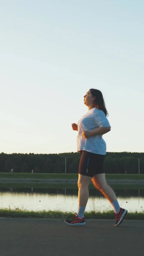 Young plump brunette overweight plus size woman jogging for weight loss. Weight Stock-Footage 300426201