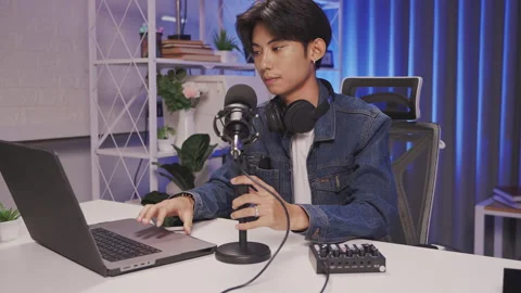 Young podcast creator setting up audio equipment in modern studio Stock Footage 310153392