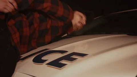 Young police officer patting down a male suspect drug dealer for weapons putting Stock Footage 112993553