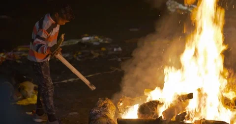 Young poor boy burning dead bodies in Manikarnika Ghat, Varanasi, India Stock Footage 113993872
