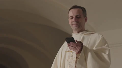 Young Pope Using Smartphone and Putting on Black Sunglasses in Church Stock Footage 186012286