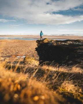 A young posing adventurous guy in a landscape of Iceland during the golden hour Stock Photos