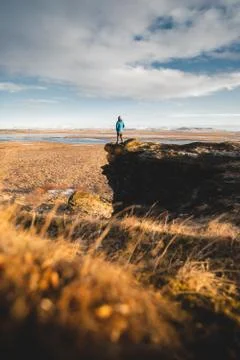A young posing adventurous guy in a landscape of Iceland during the golden hour Stock Photos