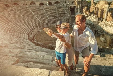 Young positive family take a self photo on the antique sights in Side, Turkey Stock Photos
