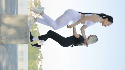 Young positive lady trainer during fitness training outdoors in park. Vertical Vídeo Stock 250126697