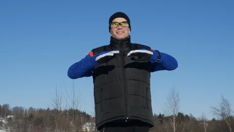 Young positive man doing exercise before skiing in the winter forest Stock-Footage 86733112