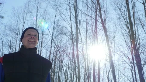 Young positive man walks through winter forest in sunny day, Steadicam shot Video stock 86859324