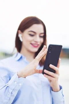 Young positive redhead manager using smartphone outdoors, depth of field Stock Photos