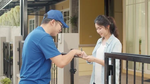 Young postal delivery courier man holding parcel boxes for sending to custome. Stock Footage 125955242