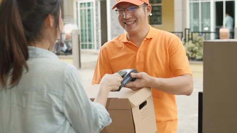 Young postal delivery courier man holding parcel boxes for sending to customer. 動画素材 129183322