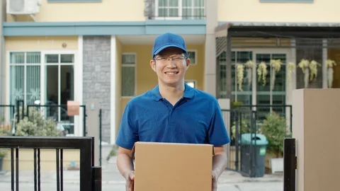 Young postal delivery courier man holding parcel boxes for sending to customer. 스톡 동영상 129184605