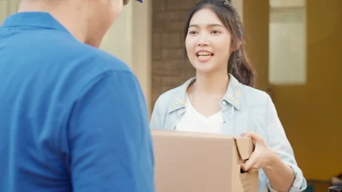 Young postal delivery courier man holding parcel boxes for sending to customer. 스톡 동영상 129186980