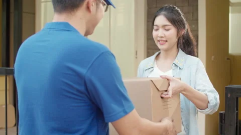 Young postal delivery courier man holding parcel boxes for sending to customer. 動画素材 135636079