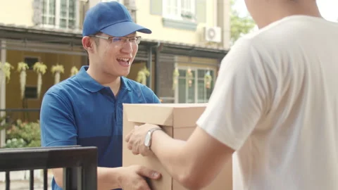 Young postal delivery courier man holding parcel boxes for sending to customer. Stock Footage 135644763
