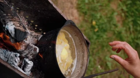 Young potatoes are boiled in a cauldron over an open fire. Summer picnic. B-B-Q Video stock 205856072