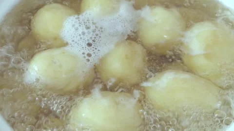 Young potatoes in bubbling boiling water, food preparation in the kitchen Stock Footage 336402521