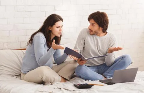 Young pregnant couple having problems in planning family budget Stock Photos