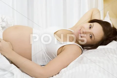 Young pregnant woman in the bed Stock-Fotos
