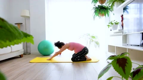 Young pregnant woman  doing back stretches to relieve lower back pain Stock Footage
