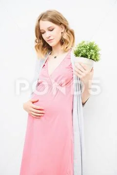 Young, pregnant woman at home. Pregnancy and motherhood. Fashion for pregnant Stock Photos