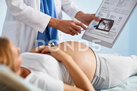Young pregnant woman looking at ultrasound scan Stock Photos