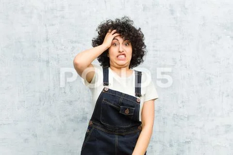 Young pretty afro woman panicking over a forgotten deadline, feeling stressed Stock Photos