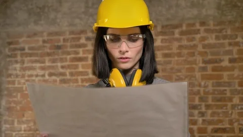 Young pretty architect woman looking at project then forward, smiling and Stock-Footage 90741753