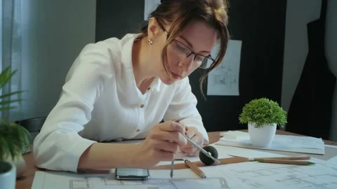 Young pretty engineer, architect or designer woman works with drawings in office Stock Footage 141782935