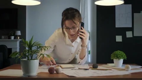 Young pretty engineer, architect or designer woman works with drawings in office Vídeos de archivo 141782995