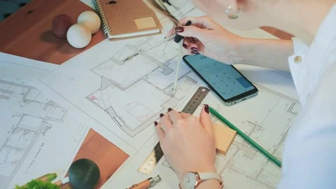 Young pretty engineer, architect or designer woman works with drawings in office Stock Footage 142727777