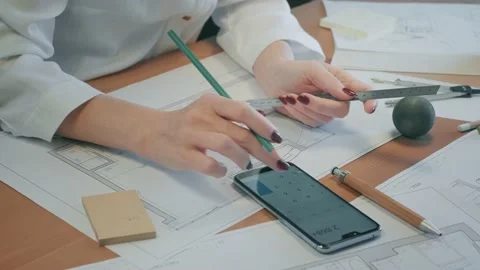 Young pretty engineer, architect or designer woman works with drawings in office Stock Footage 144976099