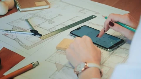 Young pretty engineer, architect or designer woman works with drawings in office Vídeos de archivo 144976143