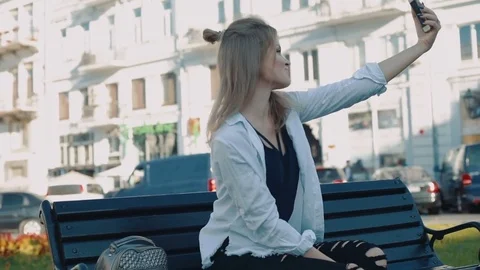 Young pretty female taking selfie using her smartphone outdoors in city Video stock 83148384