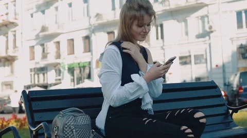 Young pretty female using her smartphone outdoors in city Video stock 83148228