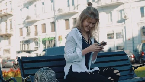 Young pretty female using her smartphone outdoors in city Stock Footage 83148358